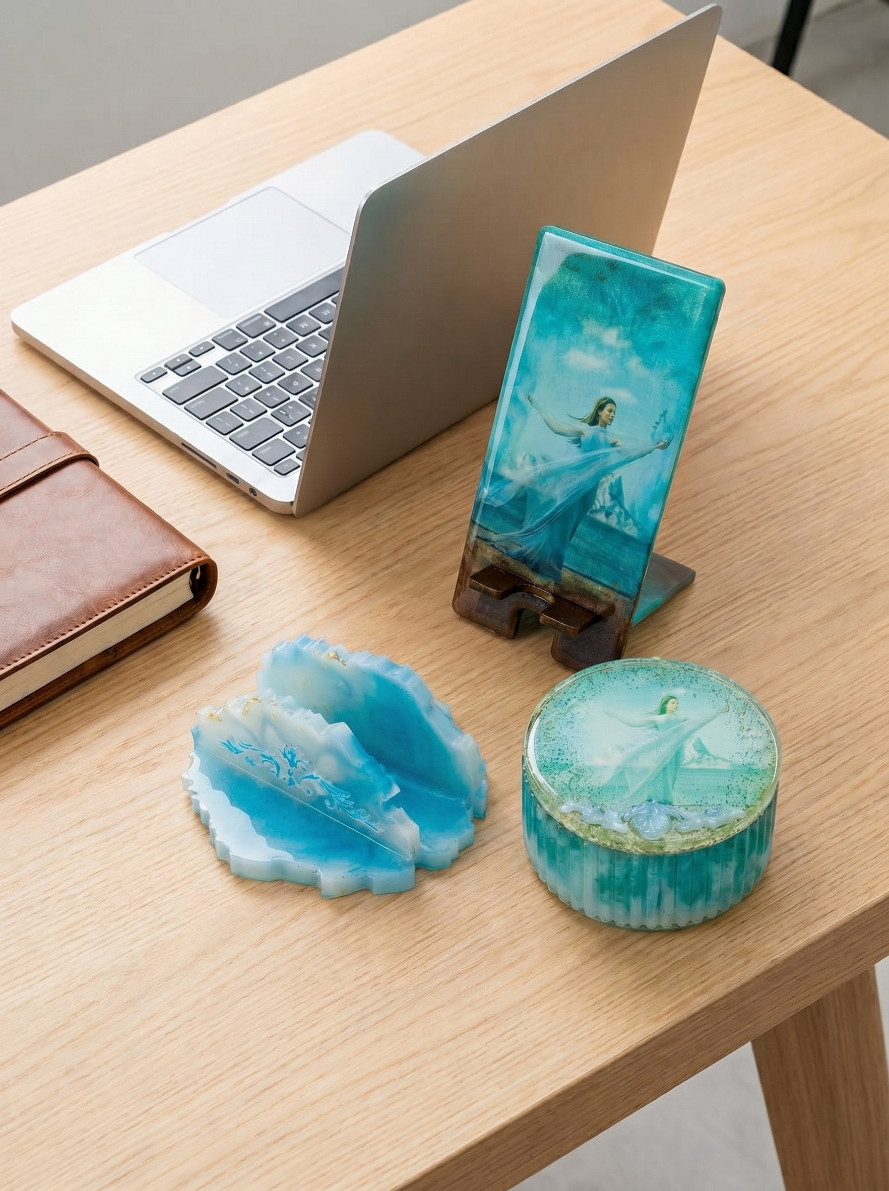 Blue resin phone stand on a desk with a laptop and notebook.